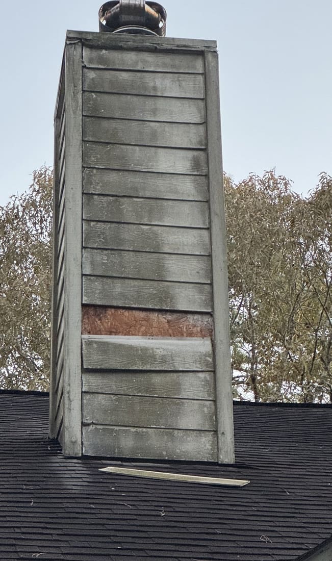 Chimney wood rot repair — grey siding