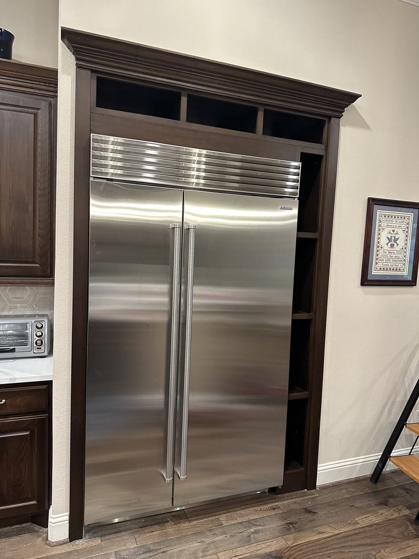 Custom fridge surround cabinetry with crown molding